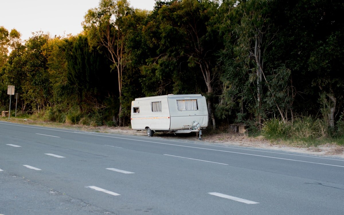 An old caravan pulled over on a quiet Australian roadside in the early evening.